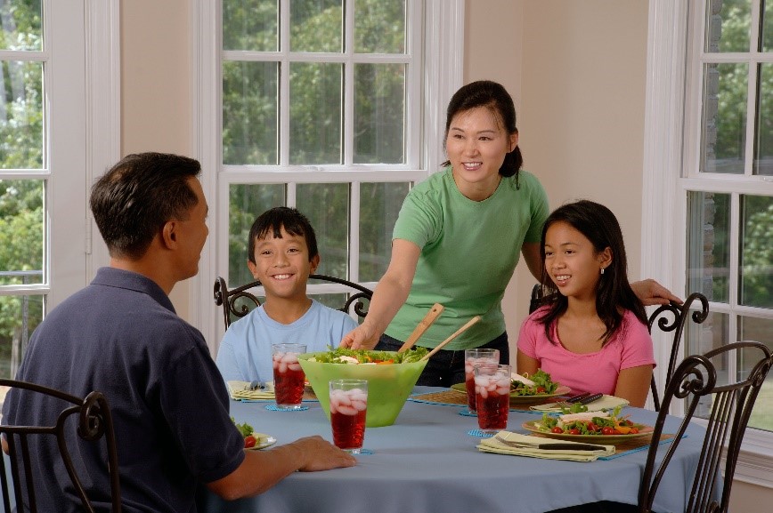 a family sat on a table prepared to eat dinner