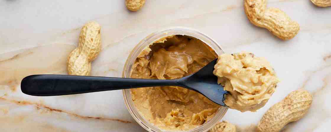 peanut butter with black spoon